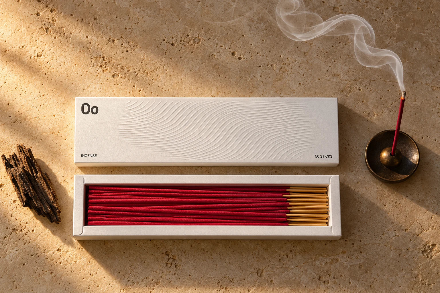 Open ivory Oo La Lab incense box with closely stacked red sticks, natural wood and a fine trail of smoke
