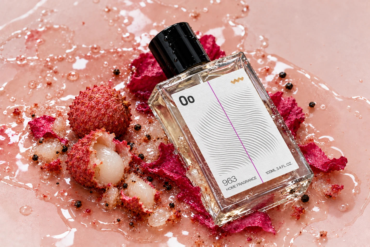 Clear Oo La Lab 963 home fragrance bottle among lychee skin, fruit and rose petals, with a textured label and gold foil symbol